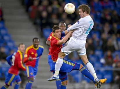 El defensa del Zenit Nicolas Lombaerts remata de cabeza el balón frente al jugador del Basiela Aleksandar Dragovic.