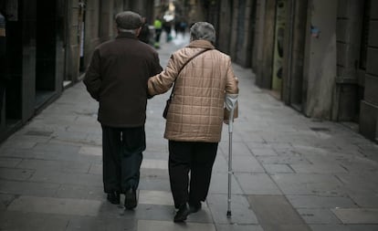 Una pareja de ancianos pasean agarrados del brazo.