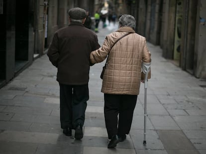 Una pareja de ancianos pasean agarrados del brazo.