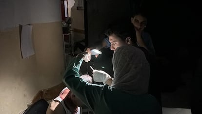 Una captura de pantalla muestra a dos doctores utilizando la linterna de un móvil para tratar a un paciente en un hospital de Gaza este lunes.
 