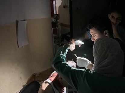 Un médico utiliza la linterna de un móvil para tratar a un paciente en un hospital de Gaza este lunes.