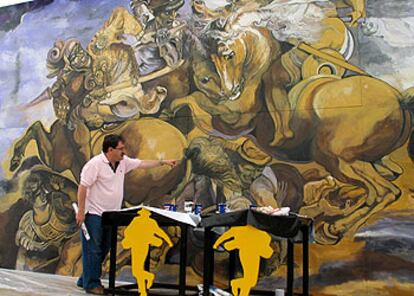 Paco Ignacio Taibo II, ante la reproducción del mural de Leonardo da Vinci que decora la carpa de la Semana Negra de Gijón.