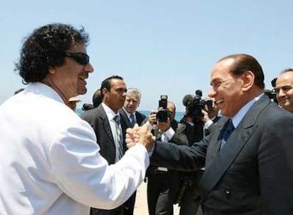 El líder libio, Muammar el Gaddafi, saluda a Silvio Berlusconi en el puerto de Sirta ayer al inicio de la visita oficial del primer ministro italiano.