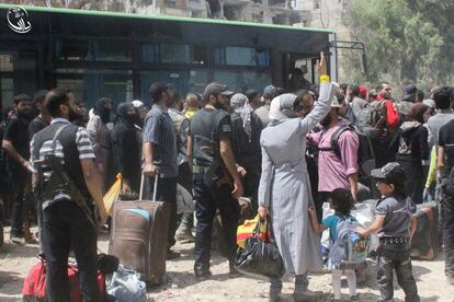 Civiles y rebeldes se preparan para ser evacuados en autobuses de la ciudad de Daraya.