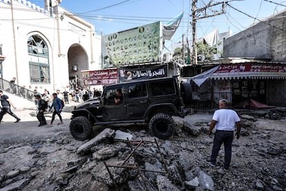 Un coche trata de circular entre los escombros en una calle de Yenín, Cisjordania. 