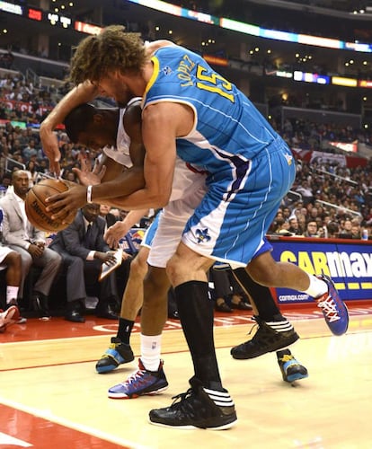 El jugador de los Clippers, Chris Paul, forcejea por el balón con Robin López, de los Hornets.