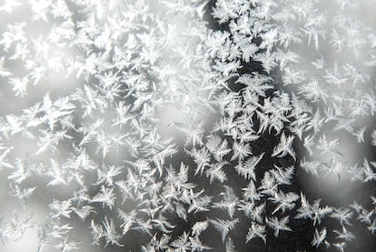 Copos de nieve en una ventana de tormenta mientras las temperaturas permanecen bajo en Iowa.