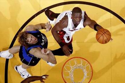 Dwyane Wade, de los Miami Heat, encara la canasta ante la presencia de Dirk Nowitzki, de los Dallas Mavericks.