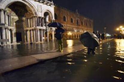 Varias personas caminan por las calles inundadas de Venecia (Italia). EFE/Archivo