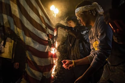 Dos manifestantes queman una bandera de EEUU en una protesta en Washington en noviembre de 2014.