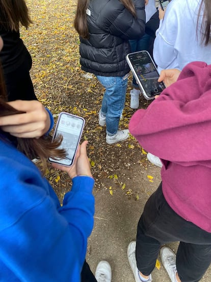 Un grupo de menores mira sus móviles.