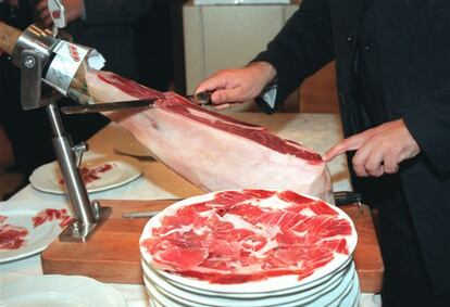 Un hombre corta jam&oacute;n ib&eacute;rico para su degustaci&oacute;n.