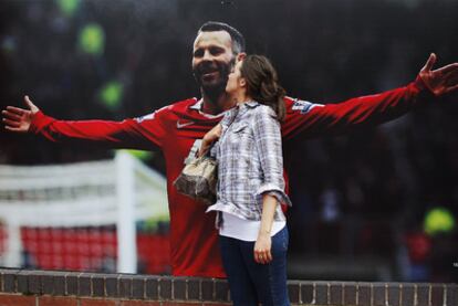 Una seguidora del Manchester United besa un póster de Ryan Giggs situado en la fachada de Old Trafford.