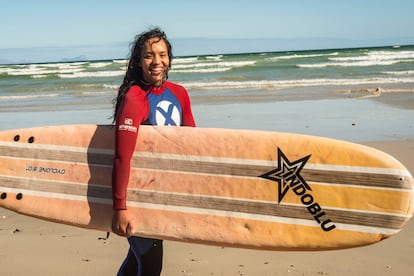 Erika, residente en Port Elizabeth, una localidad costera de Sudáfrica, termina una sesión de surf en la playa de Muizenberg, en la península del Cabo, Sudáfrica, el 12 de diciembre de 2020. Haz click sobre la imagen para ver la fotogalería completa