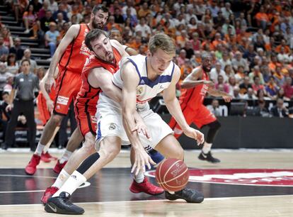 El base del Valencia Basket Guillem Vives (i) disputa un balón al base esloveno del Real Madrid Luka Doncic en un momento del partido.