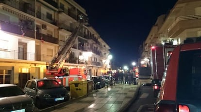 Los bomberos tratan de rescatar a los vecinos de la vivienda incendiada en Rafelbunyol en diciembre de 2014.