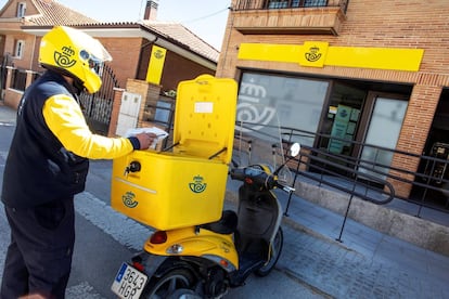 Un cartero frente a una oficina de Correos.