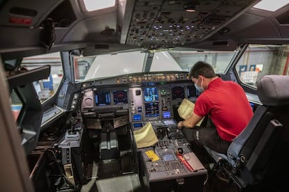 Un técnico de Iberia comprueba los dispositivos electrónicos en la cabina de la aeronave.