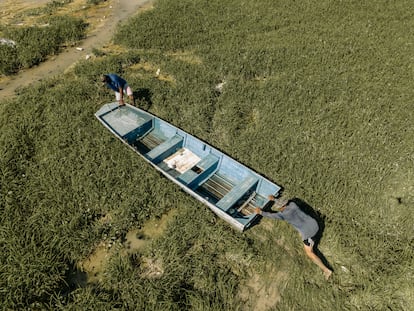 Dos pescadores de Manacapuru empujan su embarcación a lo largo del barro en dirección a una zona del río Solimões que todavía tenga agua para navegar.