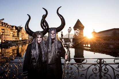 Dos personas posan disfrazadas en el Puente de la Capilla de Lucerna durante el primer día del Carnaval en Lucerna (Suiza), el 28 de febrero de 2019.