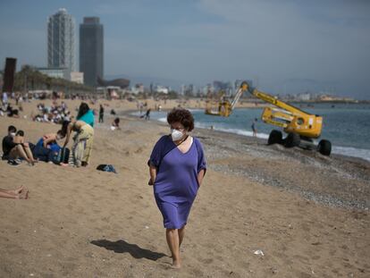 Una mujer pasea con mascarilla por la playa de la Barceloneta, en Barcelona, el pasado miércoles.