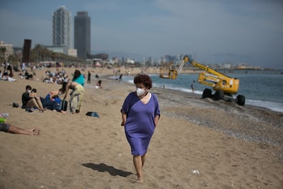 A woman wearing a face mask on Barceloneta beach in Barcelona.