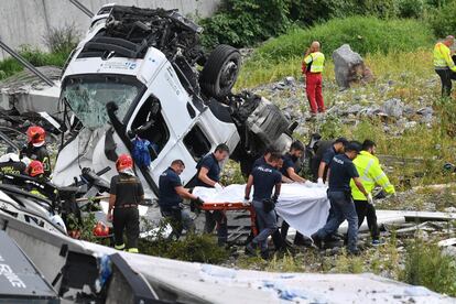 El equipo de rescate traslada a una víctima rescatada entre los escombros tras el colapso del puente Morandi en Génova (Italia). 