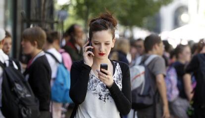 Una chica utilizando dos teléfonos móviles