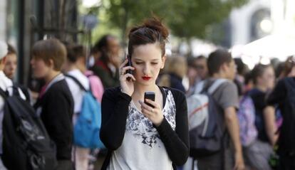 Una chica utilizando dos tel&eacute;fonos m&oacute;viles