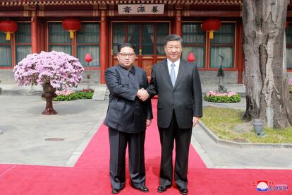 Kim Jong Un y el presidente chino, Xi Jinping, se estrechan la mano.
