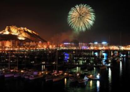 Palmera de fuegos artificiales ilumina el monte Benacantil y la marina de Alicante en la noche de San Juan.