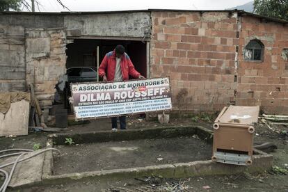 Victor Jonathan Coelho do Santos muestra una pancarta antigua y en desuso que la asociación de residentes previamente había colgado en la entrada de la favela Dilma Rousseff, de Río de Janeiro, Brasil. Después de una década en la que una creciente inflación ha golpeado a los pobres más que los ricos, el líder de la comunidad de vecinos derribó la señal que había sido colgada en la entrada de la favela como homenaje a la presidenta Rousseff.