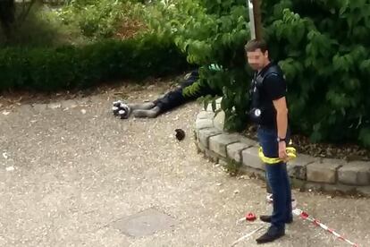 Un policía acordona el lugar en el que está el cuerpo de uno de los dos asaltantes que degollaron a un cura en la localidad francesa de Saint-Etienne-du-Rouvray.
