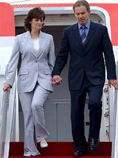 Blair y su esposa, Cherie, descienden del avión en un aeropuerto militar cercano a Seúl.