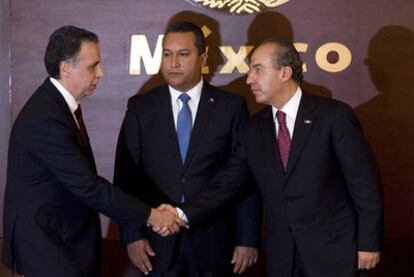 Calderón (derecha) saluda al nuevo ministro de Economía ante el de Interior, José Francisco Blake Mora.