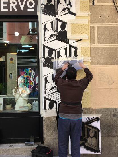El artista NSN997 con las plantillas que le ayudaron a crear su grafiti en la Calle Amparo.