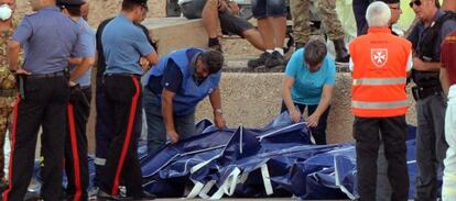 Los cad&aacute;veres del naufragio se alinean en el muelle de Lampedusa. 