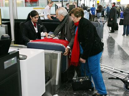 Unos pasajeros facturan su equipaje en el aeropuerto de Heathrow Internacional.