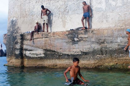 Unos niños, tras una larga sesión de educación revolucionaria, descansan  al remojo en la playa de Miramar.