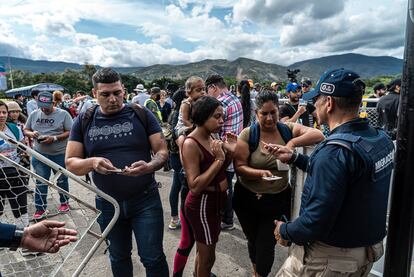 Agentes de migración de Colombia revisan documentación de ciudadanos venezolanos, unos minutos antes de la reapertura de la frontera.