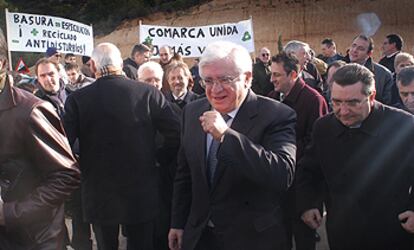 El consejero José Ramón García Antón y el presidente de la Diputación, Fernando Giner, en el acto de ayer. Al fondo, pancartas de protesta.