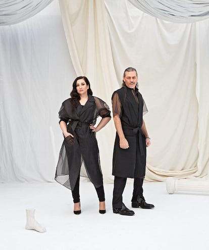 Ellos son Camela: Ángeles Muñoz lleva body de WOLFORD, leggins de MARINA RINALDI, gabardina de organza de 44STUDIO y zapatos de charol de PURA LÓPEZ. Dioni Martín viste look de 44STUDIO y botines de JIMMY CHOO.