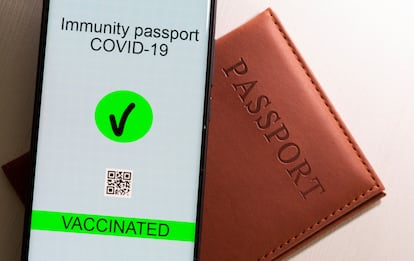Un móvil con una ilustración simulando el futuro pasaporte vacunal europeo.