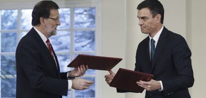 El presidente del Gobierno, Mariano Rajoy, y el secretario general del PSOE, Pedro S&aacute;nchez, durante la firma del acuerdo.