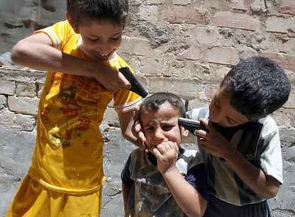 Un niño iraquí de cuatro años llora mientras otros niños fingen ejecutarle ayer en Bagdad.