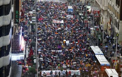 Los manifestantes se tuvieron que resguardar de la lluvia a su paso por la Gran V&iacute;a de Madrid, camino del Palacio de Oriente.