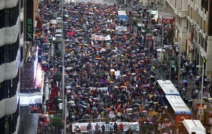 Los manifestantes se tuvieron que resguardar de la lluvia a su paso por la Gran Vía de Madrid, camino del Palacio de Oriente.
