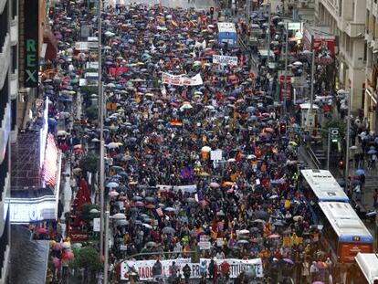 Los manifestantes se tuvieron que resguardar de la lluvia a su paso por la Gran V&iacute;a de Madrid, camino del Palacio de Oriente.