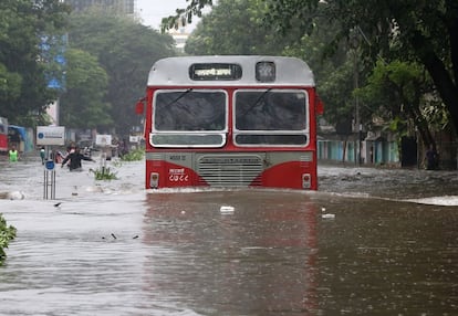 Un autobús trata de proseguir su camino a través de una carretera inundada en Bombay (India)