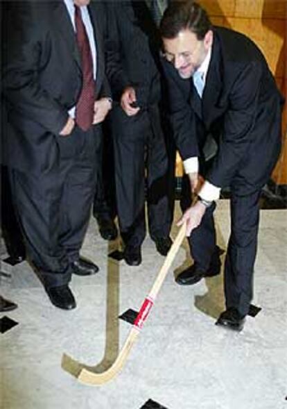 Mariano Rajoy prueba un palo de hockey, regalo de los empresarios de Tarragona, con los que se reunió ayer.